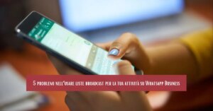 Persona che utilizza WhatsApp Business sullo smartphone, mentre digita un messaggio, con testo in sovrimpressione sui problemi delle liste broadcast